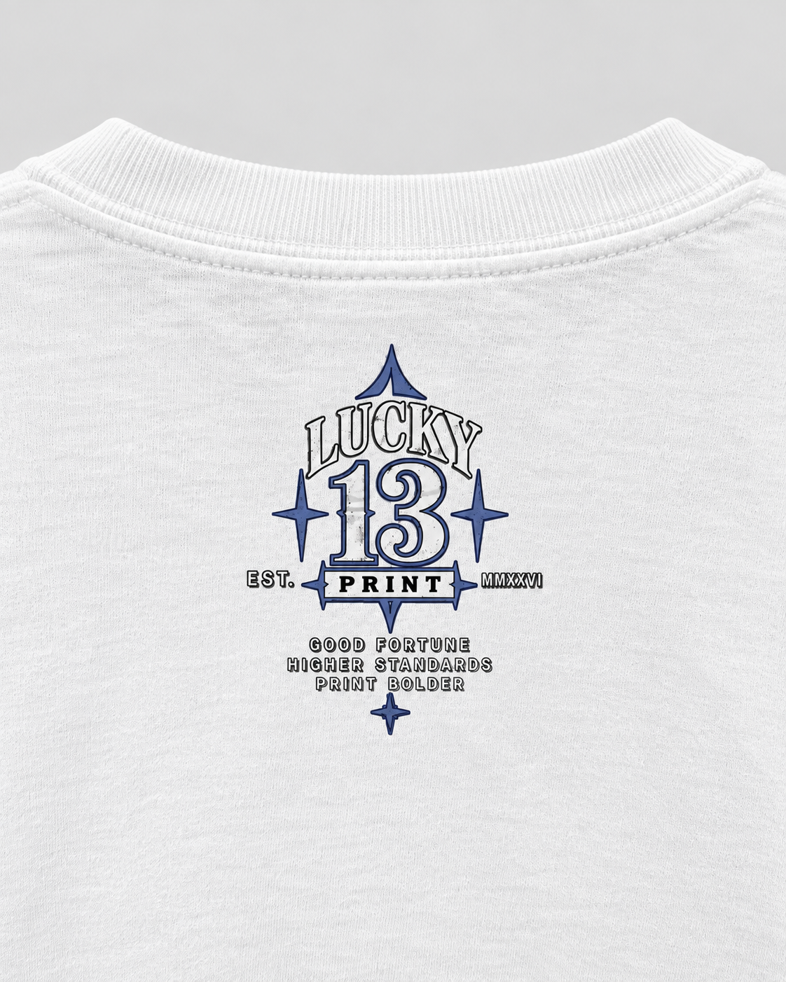 Close view of the approved upper-back Lucky 13 logo on the white Print Bolder tee